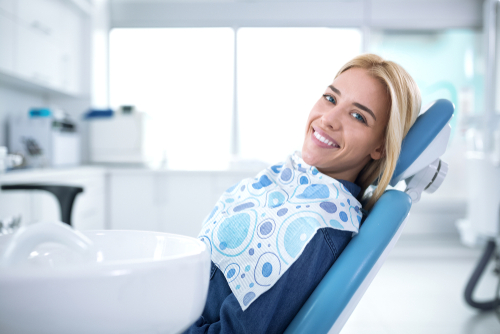 smiling and satisfied patient in a dental office after treatment-img-blog